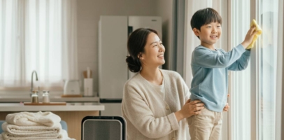 겨울 준비 집청소 중 엄마와 아이가 함께 창문을 닦으며 실내 공기를 관리하는 모습